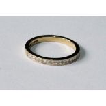 Ring of half-eternity style with band of princess-cut diamonds in 18ct gold.