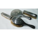 Three Edwardian silver-mounted brushes and a hand mirror, engine-turned, Birmingham 1907.