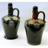 Two near-matching Royal Doulton stoneware spirit jugs, possibly by Maud Bowden,  slight colour