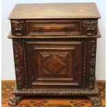 19th century oak cabinet with frieze drawer flanked by a pair of narrow drawers with mask handles,