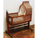 Mahogany and single caned bergere cradle on stand raised on turned supports, 93cm long.