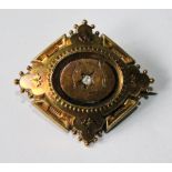 Victorian gold brooch of lozenge shape with old-cut diamond at the centre.