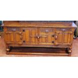 20th century carved oak sideboard having four doors and finger carved border, raised on turned