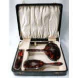 Silver and tortoiseshell three-piece toilet set with inlaid initialled plaque, Birmingham 1919,