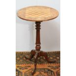 Edwardian mahogany and inlaid tripod games table on a fluted column, carved legs and feet, 47cm