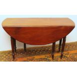 19th century mahogany drop-leaf table raised on fluted supports capped by casters, 126cm wide.