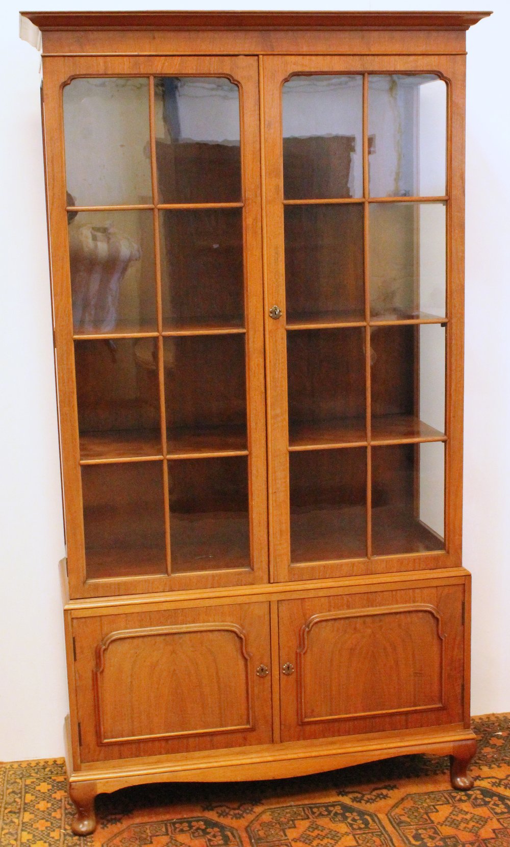 Early 20th century walnut display cabinet in the Whytock & Reid manner with moulded cornice above