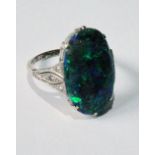 Early 20th century ring with oval, slightly convex black opal, the shoulders with small diamonds