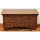 20th century carved oak blanket box with rustic shaped edge and carved floral panel, raised on