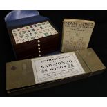 Green leather cased mahjong set with silver clasp, instructions, stands, the tiles half bone half