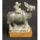 Chinese early 20th century grey green and mottled brown jade carving of a boy seated on a buffalo,