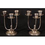 Pair of modern silver three branch candlebra with central flame finial on circular foot,