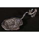 Late 19th century French silver tea strainer, the handle with cherub upon rockwork scroll,