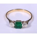 18ct gold emerald and diamond three stone ring, the central square cut emerald flanked by two
