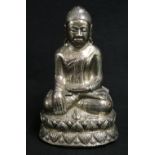 Carved wooden model of a seated Buddha covered with a silver coloured metal skin with a frog at its