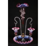 Victorian opalescent cranberry glass epergne with twin branches and central vase on a circular base,