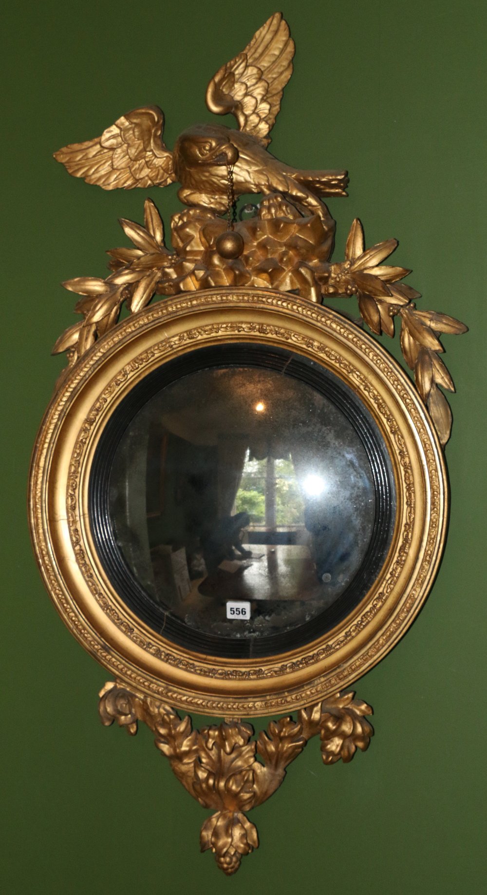 Regency gilt gesso convex wall mirror with eagle and foliate crest above a moulded frame and