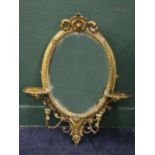 Victorian oval gilt gesso girandole mirror with pierced arabesque C scroll crest and two shelves