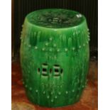 Chinese green glazed garden seat modelled in relief with trees and flowers,