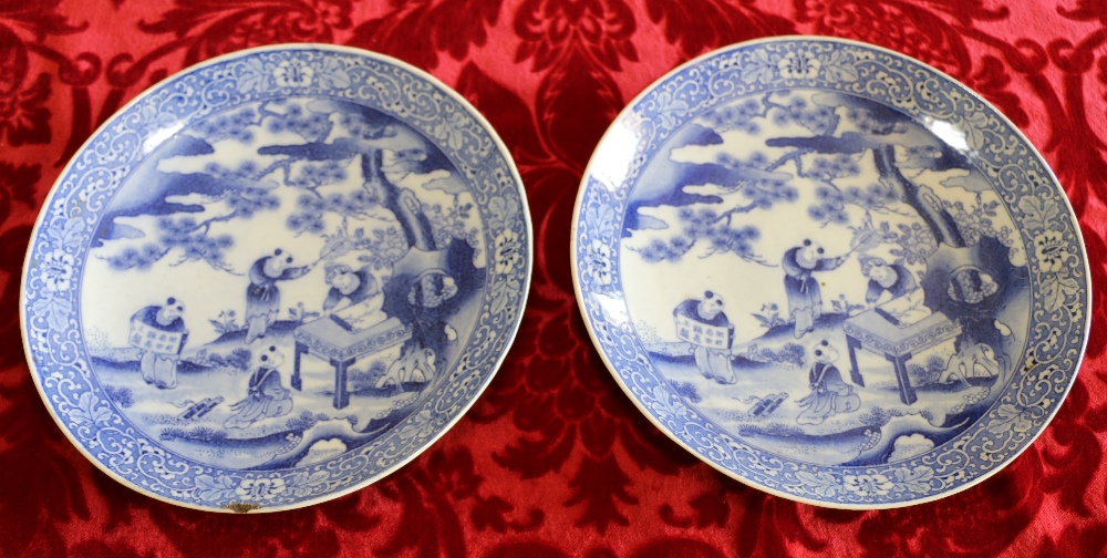Pair of transfer printed blue and white dishes depicting figures in a garden.