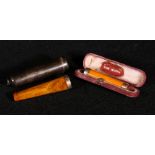 Silver cased amber cigarette holder and a 9ct mounted amber cigarette holder.