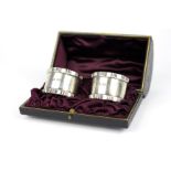 A pair of silver napkin rings within fit