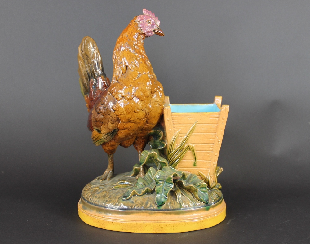 A Minton majolica hen figure by John Henk, 1880, the hen modelled standing beside a wooden box,