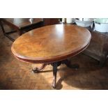 A Victorian walnut oval loo table, on carved scroll legs,