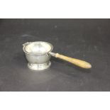 A silver tea strainer and stand A & Co Ltd, strainer London 1923 with turned wooden handle 15.