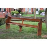 A near pair of Victorian pine pews, with open backs,