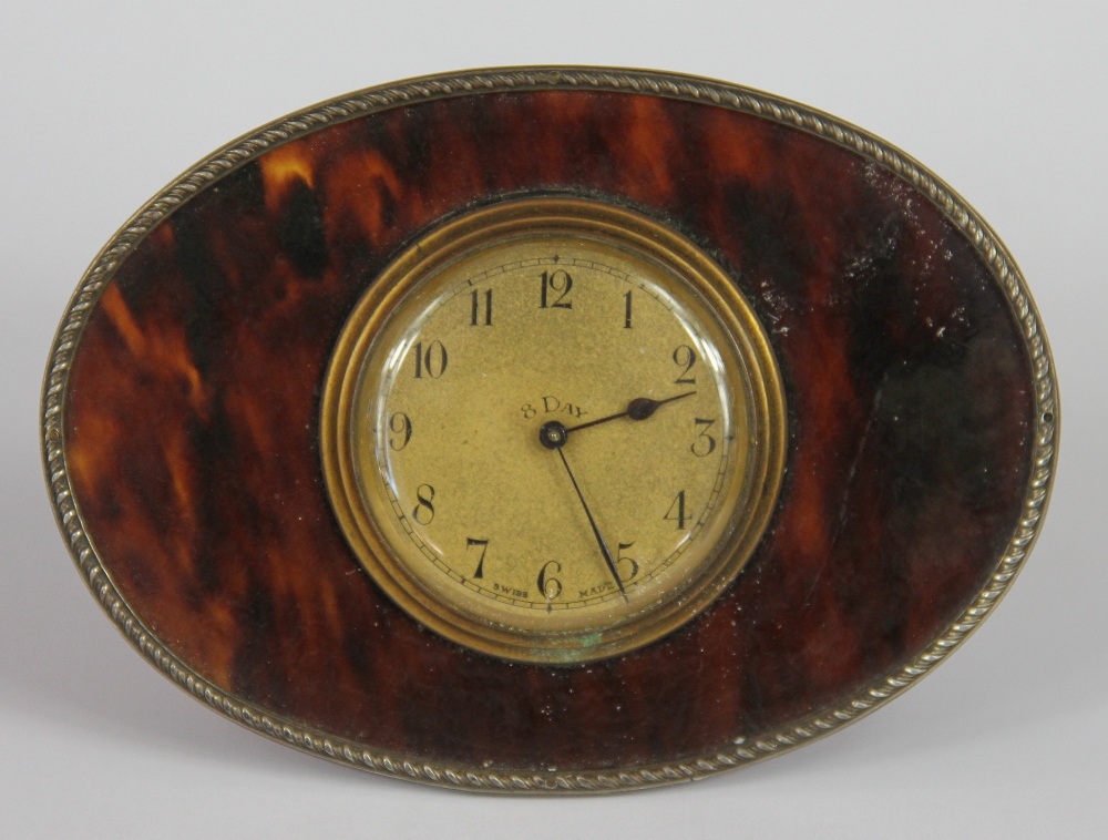 An early 20th century silver mounted tortoiseshell desk time piece, brass dial with Arabic numerals,