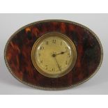 An early 20th century silver mounted tortoiseshell desk time piece, brass dial with Arabic numerals,