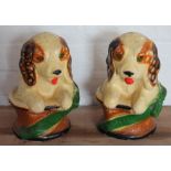A pair of painted plaster models of dogs seated in baskets, with jewelled eyes,