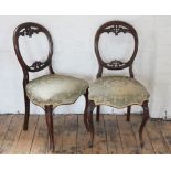 A set of four Victorian carved walnut dining chairs,