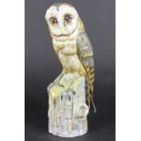A German porcelain model of a barn owl, perched on a tree stump, impressed number 2450,