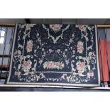 A French tapestry carpet, decorated with an all over foliate design against a black ground,