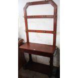 A late Victorian walnut hall stand, with eight brass pegs above a drawer and under tier,