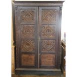 A Victorian carved oak two door livery cupboard, with panelled doors, on bracket feet,