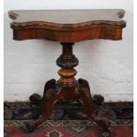 A Victorian walnut serpentine card table, on turned column and four scroll legs,