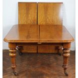 A Victorian golden oak concertina action extending dining table, with two spare leaves,