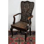 A Continental carved oak arm chair, with foliate panelled back and seat on cabriole legs,