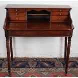 A Regency and later Carlton House style desk, with six drawers, on turned and tapered legs,