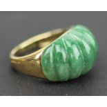 A 9ct yellow gold and jade set dress ring, the carved bombe shaped jade inset into 9ct yellow gold,