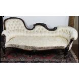 A Victorian carved and stained walnut chaise long, with scroll frame and button back upholstery on