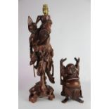 A Chinese carved hardwood figural lamp of a man gathering fruit,