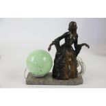 An Art Deco style spelter table lamp, with green mottle glass shade,