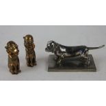 A pair of brass novelty cruets in the form of dogs in cricket caps, 7.