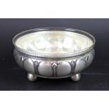 A WMF plated dish, on ball toes with clear glass liner,