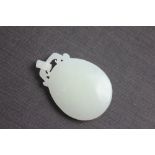 A Chinese white jade coloured stone pendant, of oval form,