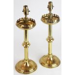 A pair of Gothic revival lacquered brass candlesticks, converted for electricity 44.